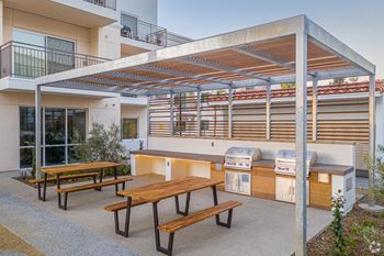 A patio with a table and chairs under a roof.